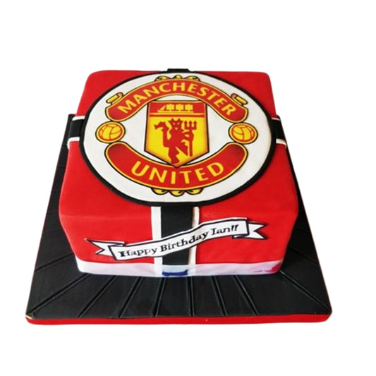 Manchester United celebration cake with edible banner message, honoring the club's legacy in red and gold.